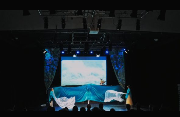 Bühne mit blauer Dekoration und Projektion von schneebedeckten Bergen.